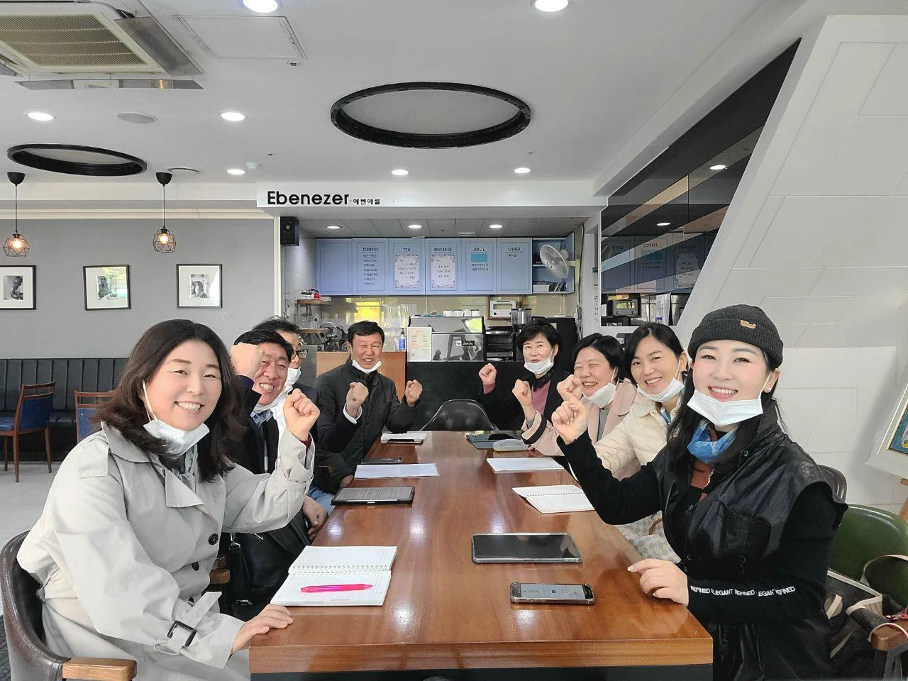 탁자에 둘러앉아 함께 웃고 있는 오라 공동체 사람들